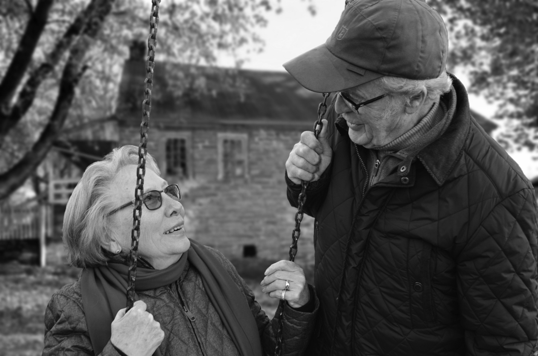 Retired couple laughing together on a swing